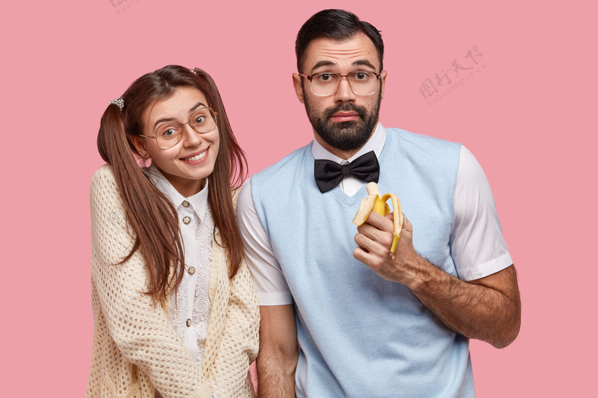书呆子两位聪明开朗的朋友在休息日相聚 在镜头前摆姿势 吃香蕉 戴眼镜同学友谊男孩