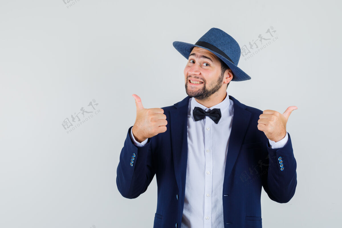 人年轻人穿着西装 戴着帽子 向上竖起大拇指 看上去很高兴 正面照拇指人西装