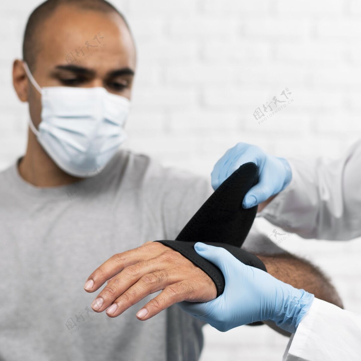 物理男人的手腕被女理疗师包起来了创伤运动手套