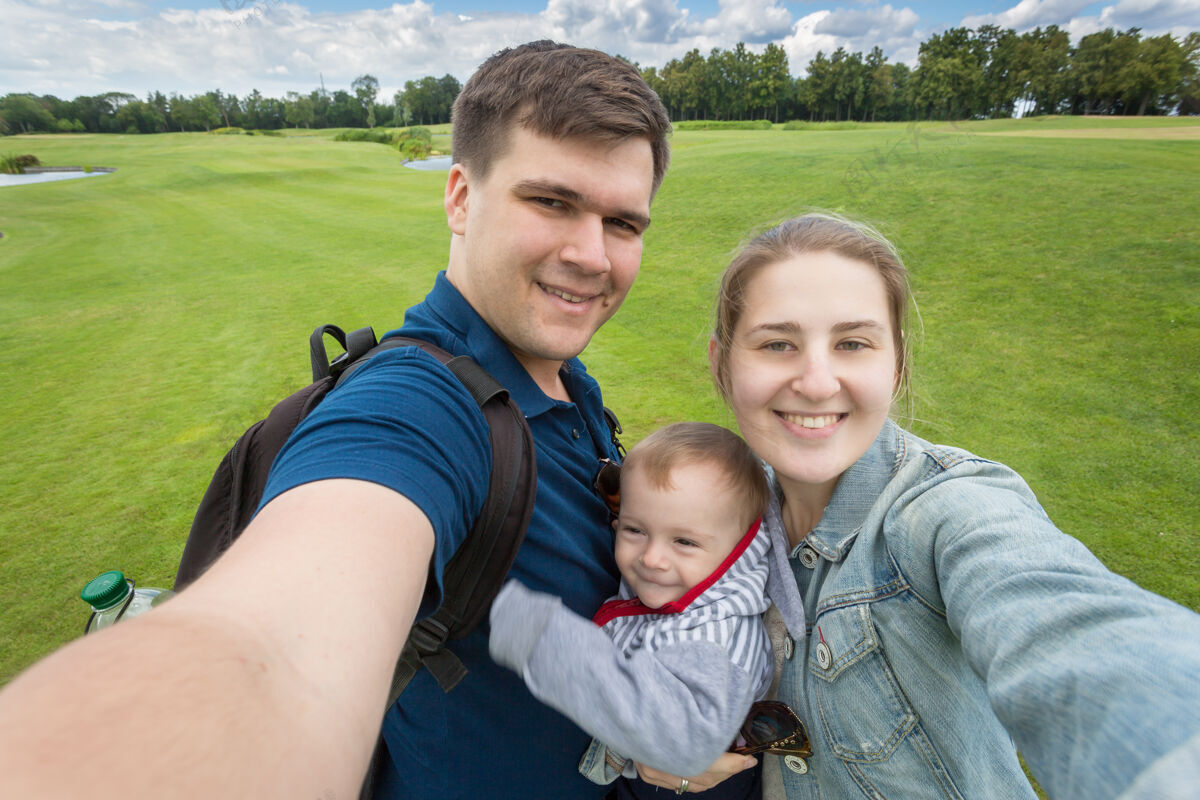 阳光与可爱的男婴在公园放松快乐家庭的自拍图片周末乡村田野