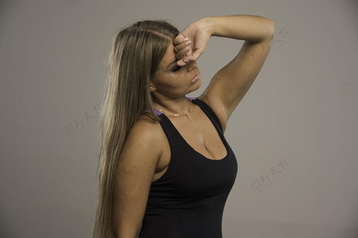 成人穿着运动胸罩的女模特把手放在额头上 看起来很累 侧视图健身人运动